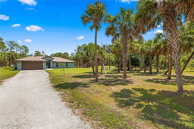 1187 16th Ave NE, Naples, FL 34120 - view of front of property with a garage, a front lawn, gravel driveway, and view of wooded area