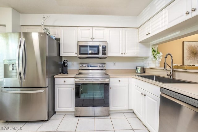6900 Huntington Lakes Cir Unit 102, Naples, FL 34119 - kitchen with appliances with stainless steel finishes, light countertops, white cabinets, and light tile patterned floors