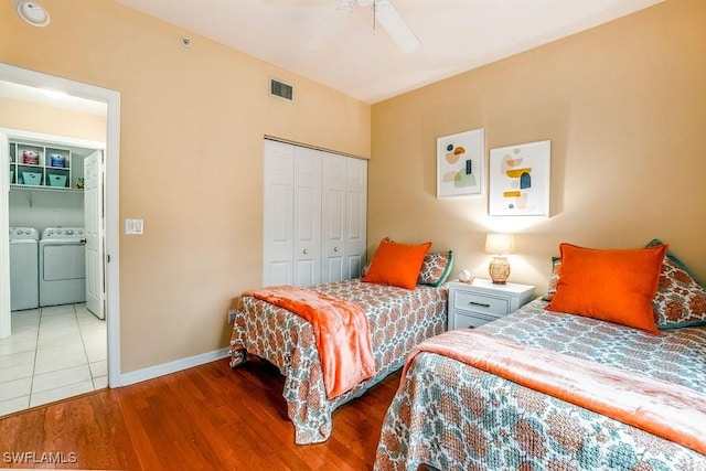 6900 Huntington Lakes Cir Unit 102, Naples, FL 34119 - bedroom featuring separate washer and dryer, a closet, wood finished floors, baseboards, and ceiling fan