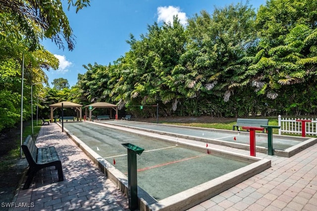 6900 Huntington Lakes Cir Unit 102, Naples, FL 34119 - surrounding community featuring a bocce ball area and view of wooded area