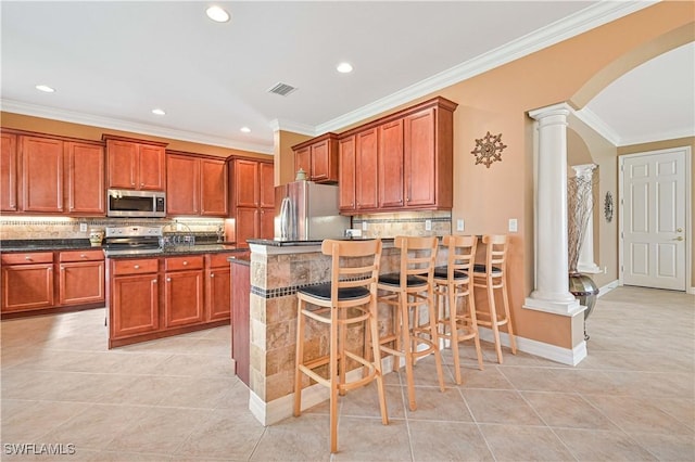 10212 Mimosa Silk Dr, Fort Myers, FL 33913 - kitchen featuring appliances with stainless steel finishes, ornate columns, arched walkways, light tile patterned flooring, and tasteful backsplash