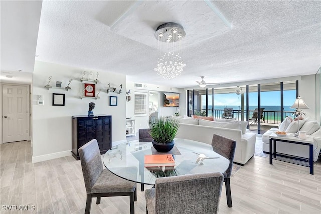 100 N Collier Blvd Unit 1002, Marco Island, FL 34145 - dining room with a textured ceiling, a chandelier, light wood finished floors, and baseboards
