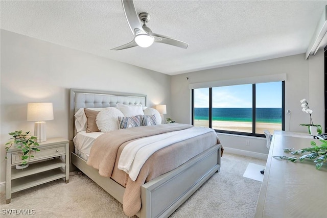 100 N Collier Blvd Unit 1002, Marco Island, FL 34145 - bedroom with light carpet, a textured ceiling, baseboards, a ceiling fan, and a water view