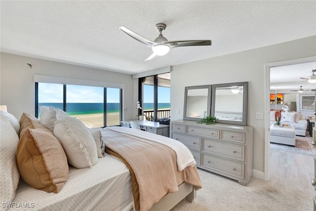 100 N Collier Blvd Unit 1002, Marco Island, FL 34145 - bedroom with access to outside, a water view, a ceiling fan, light carpet, and a textured ceiling