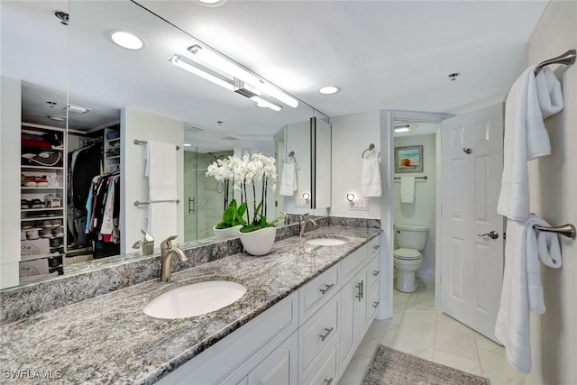 100 N Collier Blvd Unit 1002, Marco Island, FL 34145 - full bathroom with double vanity, toilet, a spacious closet, and a shower with shower door