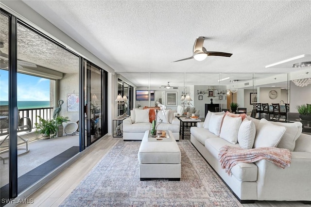 100 N Collier Blvd Unit 1002, Marco Island, FL 34145 - living room with wood finished floors, a textured ceiling, a ceiling fan, and a water view
