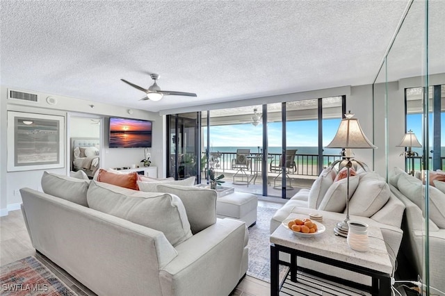 100 N Collier Blvd Unit 1002, Marco Island, FL 34145 - living area with a textured ceiling, light wood-style floors, and a ceiling fan