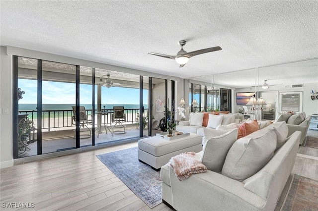100 N Collier Blvd Unit 1002, Marco Island, FL 34145 - living room featuring a ceiling fan, healthy amount of natural light, a textured ceiling, and wood finished floors