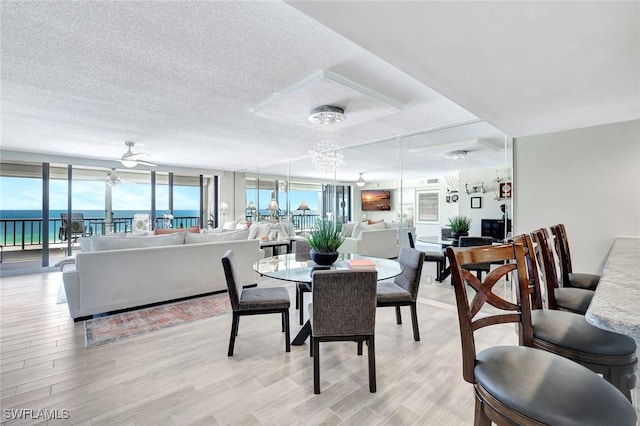 100 N Collier Blvd Unit 1002, Marco Island, FL 34145 - dining room with a chandelier, light wood-style floors, and a textured ceiling