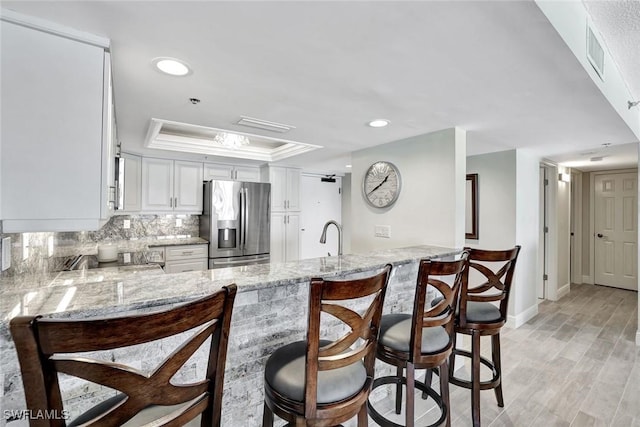 100 N Collier Blvd Unit 1002, Marco Island, FL 34145 - kitchen with stainless steel fridge with ice dispenser, a peninsula, light stone countertops, and recessed lighting