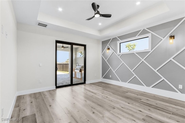 224 NW 14th Pl, Cape Coral, FL 33993 - empty room featuring a raised ceiling, ceiling fan, wood finished floors, baseboards, and recessed lighting