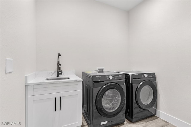 224 NW 14th Pl, Cape Coral, FL 33993 - laundry room featuring washer and dryer, light wood-style flooring, baseboards, and cabinet space