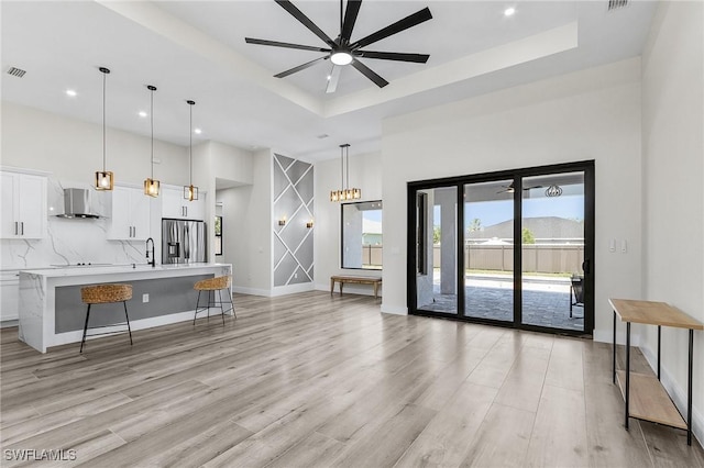 224 NW 14th Pl, Cape Coral, FL 33993 - living room with a ceiling fan, a tray ceiling, recessed lighting, light wood-style floors, and baseboards