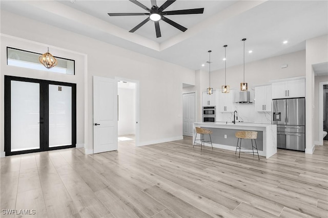 224 NW 14th Pl, Cape Coral, FL 33993 - unfurnished living room featuring a towering ceiling, a ceiling fan, a sink, light wood finished floors, and recessed lighting