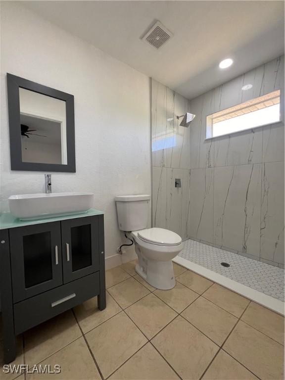 1412/1414 W 12th St, Lehigh Acres, FL 33972 - full bathroom with vanity, a shower stall, toilet, tile patterned flooring, and baseboards