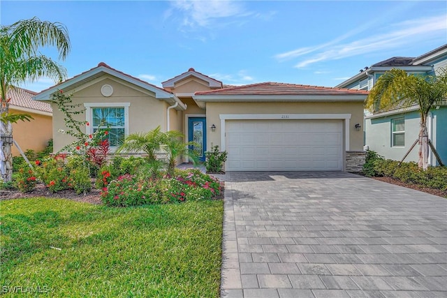 2131 Hamlin St, Naples, FL 34120 - single story home featuring stucco siding, decorative driveway, a garage, and a front yard