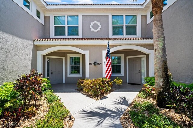 23581 Sandycreek Ter Unit 1107, Estero, FL 34135 - view of exterior entry featuring stucco siding, covered porch, and a tile roof
