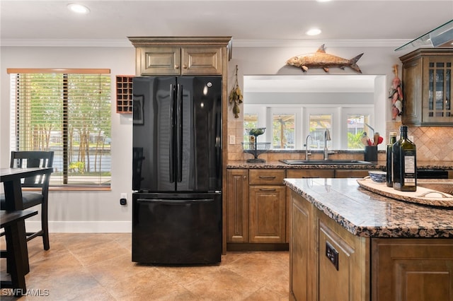 155 Donna Ct, Punta Gorda, FL 33950 - kitchen featuring freestanding refrigerator, a sink, backsplash, dark stone counters, and healthy amount of natural light