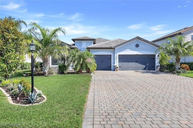 17476 Ashcomb Way, Estero, FL 33928 - view of front of property with a front lawn, a garage, decorative driveway, and stucco siding