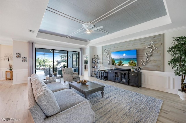 17476 Ashcomb Way, Estero, FL 33928 - living area with a raised ceiling, a decorative wall, wood finished floors, a ceiling fan, and wainscoting