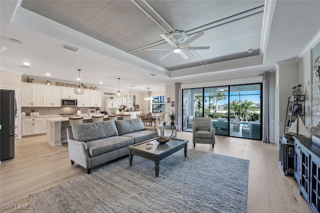 17476 Ashcomb Way, Estero, FL 33928 - living room with a tray ceiling, crown molding, light wood-type flooring, and a ceiling fan