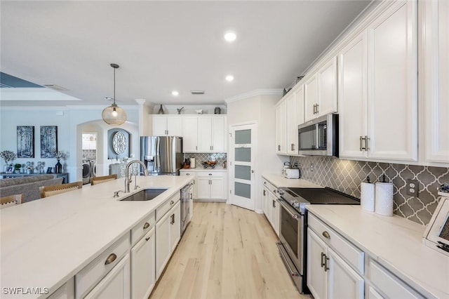 17476 Ashcomb Way, Estero, FL 33928 - kitchen with appliances with stainless steel finishes, arched walkways, crown molding, white cabinetry, and recessed lighting