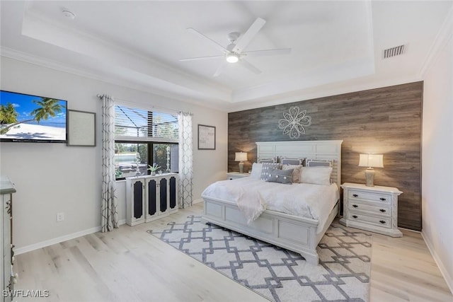 17476 Ashcomb Way, Estero, FL 33928 - bedroom with a tray ceiling, light wood finished floors, an accent wall, crown molding, and ceiling fan