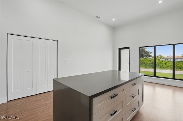 2815 45th St W, Lehigh Acres, FL 33971 - kitchen with dark countertops, white cabinetry, light wood-style floors, recessed lighting, and a towering ceiling