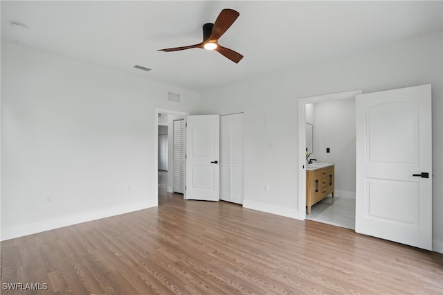 2815 45th St W, Lehigh Acres, FL 33971 - unfurnished bedroom with light wood finished floors, baseboards, connected bathroom, and a sink