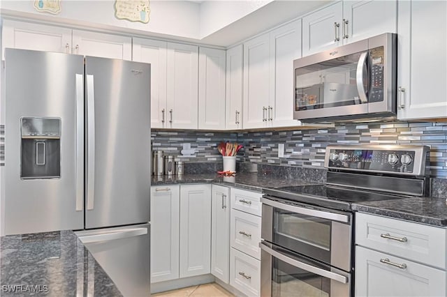 1826 SE 6th Ave, Cape Coral, FL 33990 - kitchen featuring appliances with stainless steel finishes, backsplash, dark stone counters, white cabinets, and light tile patterned floors