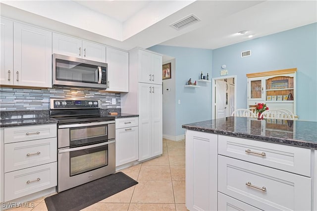 1826 SE 6th Ave, Cape Coral, FL 33990 - kitchen with appliances with stainless steel finishes, decorative backsplash, white cabinets, and light tile patterned floors