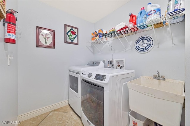 1826 SE 6th Ave, Cape Coral, FL 33990 - laundry area featuring washing machine and clothes dryer, light tile patterned flooring, and baseboards