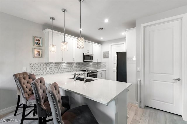 7619 Morgan Way, Naples, FL 34119 - kitchen with stainless steel appliances, a sink, light countertops, a peninsula, and recessed lighting