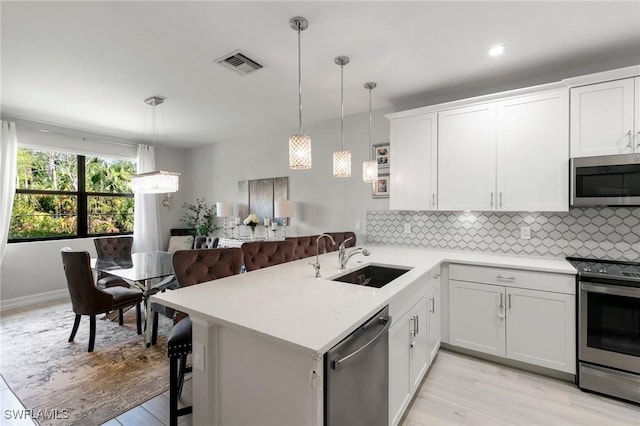 7619 Morgan Way, Naples, FL 34119 - kitchen with stainless steel appliances, a sink, light countertops, backsplash, and white cabinetry
