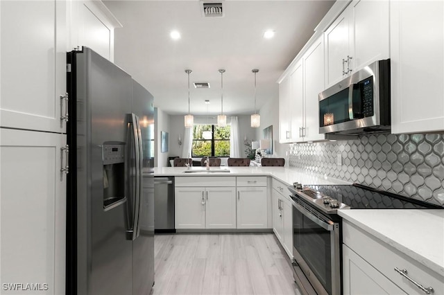 7619 Morgan Way, Naples, FL 34119 - kitchen featuring stainless steel appliances, a sink, light countertops, decorative backsplash, and white cabinets