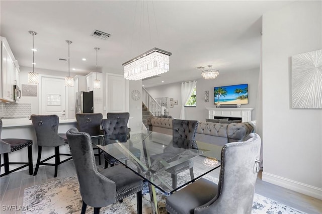 7619 Morgan Way, Naples, FL 34119 - dining space with light wood-type flooring, stairway, baseboards, a chandelier, and recessed lighting