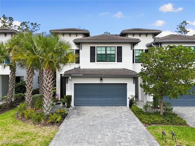 7619 Morgan Way, Naples, FL 34119 - view of front facade with an attached garage, stucco siding, and decorative driveway