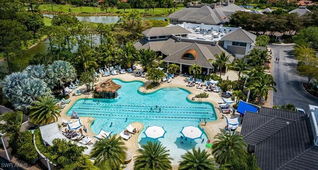 2366 Alexander Palm Dr, Naples, FL 34105 - bird's eye view of a pool, a tree filled landscape, and a large body of water