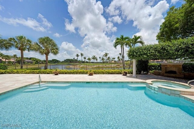 2366 Alexander Palm Dr, Naples, FL 34105 - view of swimming pool featuring a pool with connected hot tub, a water view, and a patio