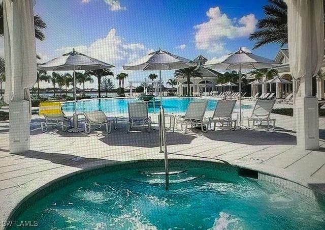 14037 Hawks Eye Ct, Estero, FL 33928 - community pool featuring a patio area