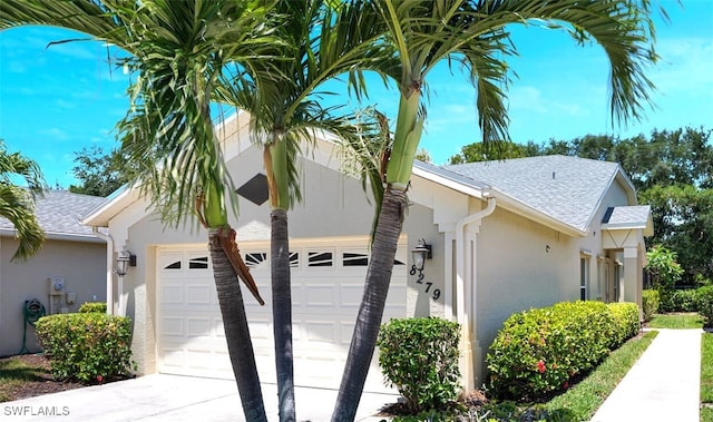 8279 Ibis Cove Cir Unit A136, Naples, FL 34119 - view of home's exterior featuring stucco siding, an attached garage, and roof with shingles