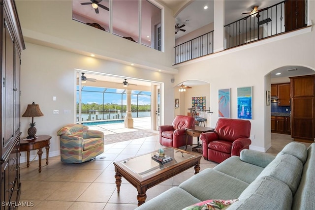 1128 NW 43rd Ave, Cape Coral, FL 33993 - living area featuring a ceiling fan, arched walkways, light tile patterned flooring, a water view, and a towering ceiling