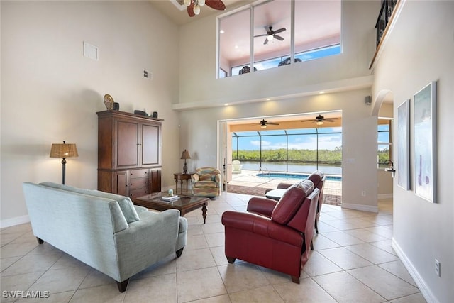 1128 NW 43rd Ave, Cape Coral, FL 33993 - living room featuring ceiling fan, a towering ceiling, baseboards, a water view, and light tile patterned flooring