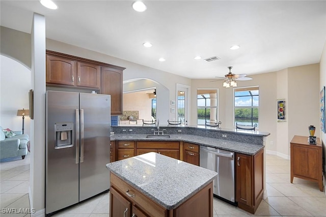 1128 NW 43rd Ave, Cape Coral, FL 33993 - kitchen featuring appliances with stainless steel finishes, arched walkways, a ceiling fan, a sink, and dark stone counters