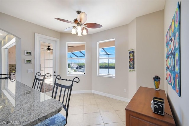 1128 NW 43rd Ave, Cape Coral, FL 33993 - dining area with arched walkways, ceiling fan, baseboards, light tile patterned flooring, and french doors