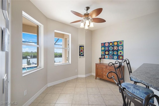 1128 NW 43rd Ave, Cape Coral, FL 33993 - dining room with ceiling fan, light tile patterned floors, and baseboards