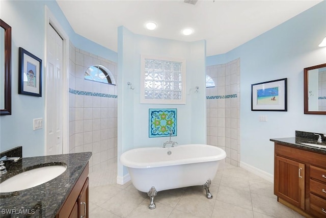 1128 NW 43rd Ave, Cape Coral, FL 33993 - full bath with a walk in shower, a freestanding bath, two vanities, and tile patterned floors