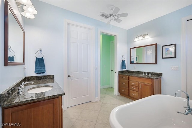 1128 NW 43rd Ave, Cape Coral, FL 33993 - full bath featuring two vanities, tile patterned flooring, a freestanding tub, a ceiling fan, and baseboards