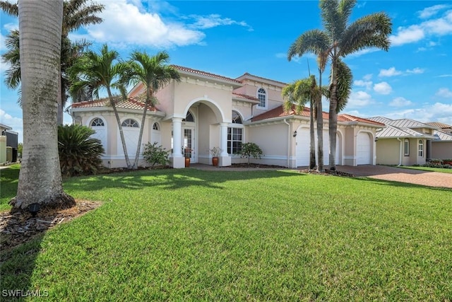 1128 NW 43rd Ave, Cape Coral, FL 33993 - mediterranean / spanish home with a garage, driveway, stucco siding, a front yard, and a tile roof