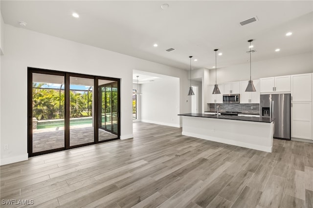 2110 SW 52nd Ter, Cape Coral, FL 33914 - kitchen featuring appliances with stainless steel finishes, dark countertops, white cabinets, open floor plan, and recessed lighting